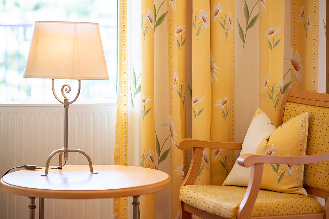 Lampe mit Sessel im Blumenzimmer im Hotel Gasthof Scheer